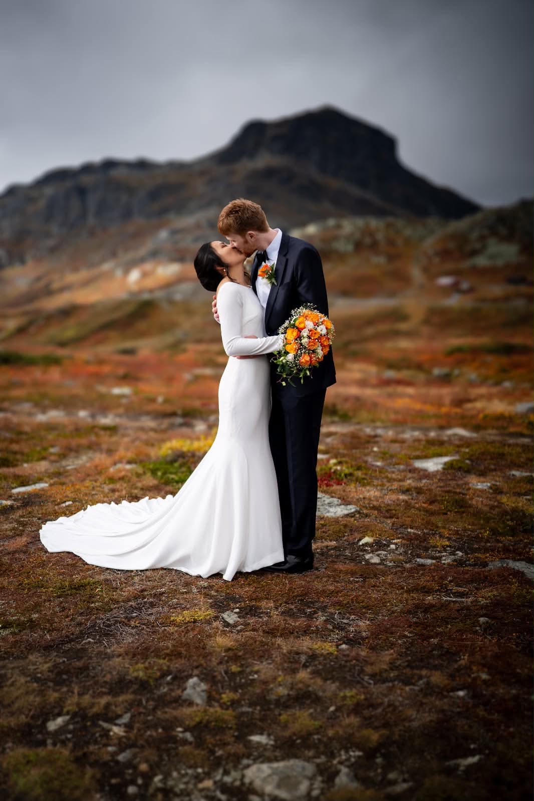 Sandra and Benjamin kissing in the mountains on their wedding day